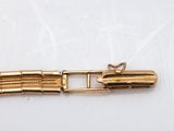a close up of a gold plated metal object on a white surface