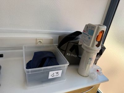 un récipient en plastique posé sur un plan de travail, à côté d'une bouteille d'eau