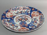 a blue and white plate with red flowers on it
