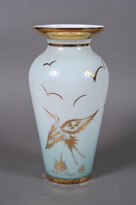 a vase with a bird on it sitting on a table