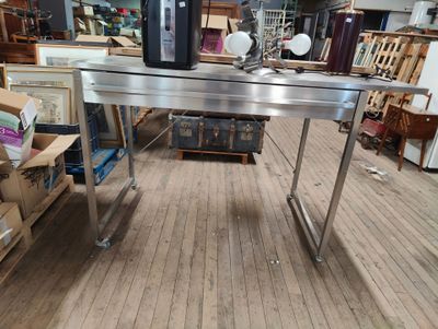 a large stainless steel table in the middle of a room