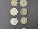 six types différents de pièces d'argent sur une surface noire