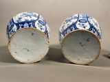two blue and white vases sitting next to each other
