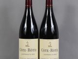 two bottles of wine sitting on top of a table next to each other