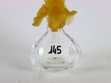 un petit vase en verre contenant une petite figurine