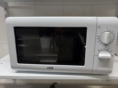 un micro-ondes blanc posé sur un plan de travail dans une cuisine