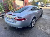 the rear end of a silver sports car parked in a parking lot