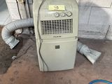 a small air conditioner sitting on the floor next to a hose