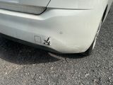a white car that has a dent in the front of it
