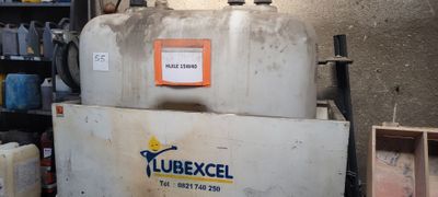 une photo d'un réfrigérateur dans un garage, sur lequel est accrochée une pancarte