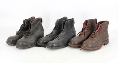 three pairs of boots are lined up on a white surface