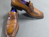 pair of men ' s brown leather loafers on a gray surface