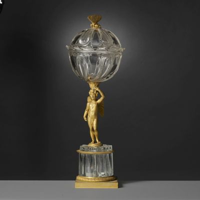 a gold and crystal figurine of a woman holding a globe