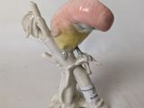 a small figurine of a bird on a branch