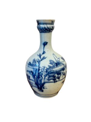 un vase bleu et blanc posé sur une surface blanche