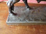 a bronze statue of a horse on a wooden table