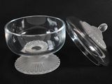 a glass bowl with a lid on a black background