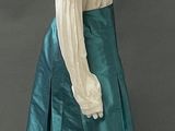 a mannequin wearing a green skirt and a white blouse