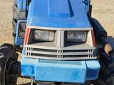 a blue tractor that is parked in the dirt