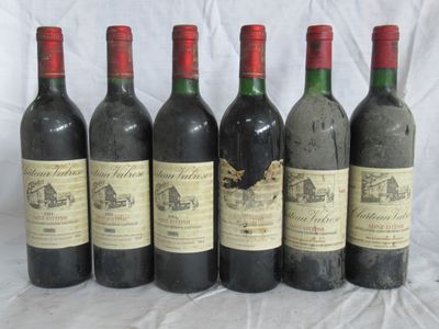 six bouteilles de vin sont alignées sur une table