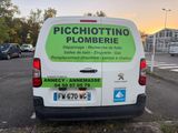 a white van parked in a parking lot with a green sign on the back of it