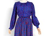une photo d'un mannequin portant une robe bleue ornée de fleurs rouges