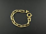 a close up of a gold chain bracelet on a black surface