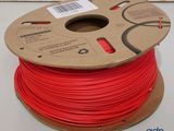a reel of red pla filamant on a white surface