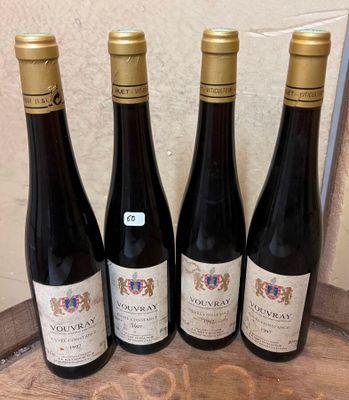 quatre bouteilles de vin sont alignées sur une table en bois
