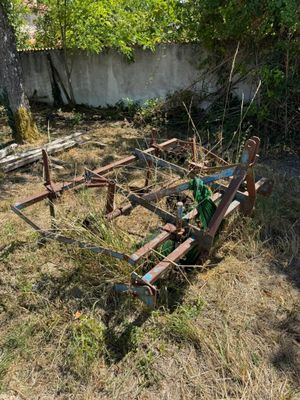 a tractor that is sitting in the grass near a fence