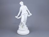 une statue blanche représentant une femme tenant un panier, posée sur un socle