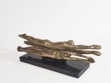 sculpture en bronze représentant deux mains qui se tiennent l'une l'autre, posée sur un socle noir