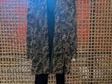 black and white zebra print jacket and pants on display in front of a woven wall