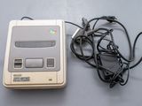 une console de jeux Nintendo Classic posée à côté d'un chargeur sur une table