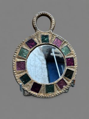 une image représentant un petit miroir orné d'un motif multicolore