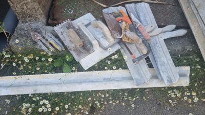 un tas d'outils posé par terre près d'un arbre