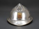 a silver helmet that has a gold button on it