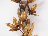 a gold leaf wall sconce on a white background