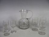 several glasses and a pitcher are sitting on a table