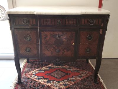une petite table avec un plateau en marbre et un tapis posé au sol