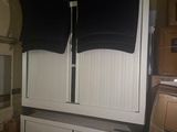 two black shirts hanging on a white cabinet in a kitchen