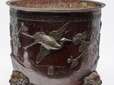 un saladier en métal orné d'un motif représentant un oiseau et des fleurs