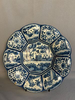 a blue and white plate with a picture of people on it