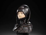 a carved bust of a woman wearing a hood and scarf