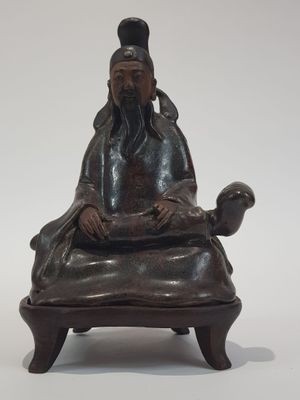 statue of a man sitting on a chair with a cat on his lap