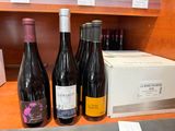 trois bouteilles de vin sont posées sur un comptoir, à côté d'une boîte de vin