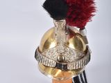 un casque doré surmonté d'une plume rouge