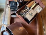 une table en bois sur laquelle est posée une valise remplie d'objets divers
