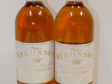 two bottles of wine sitting next to each other on a table