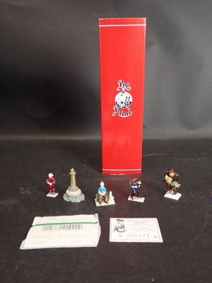 des figurines représentant un groupe de personnes debout à côté d'une boîte rouge